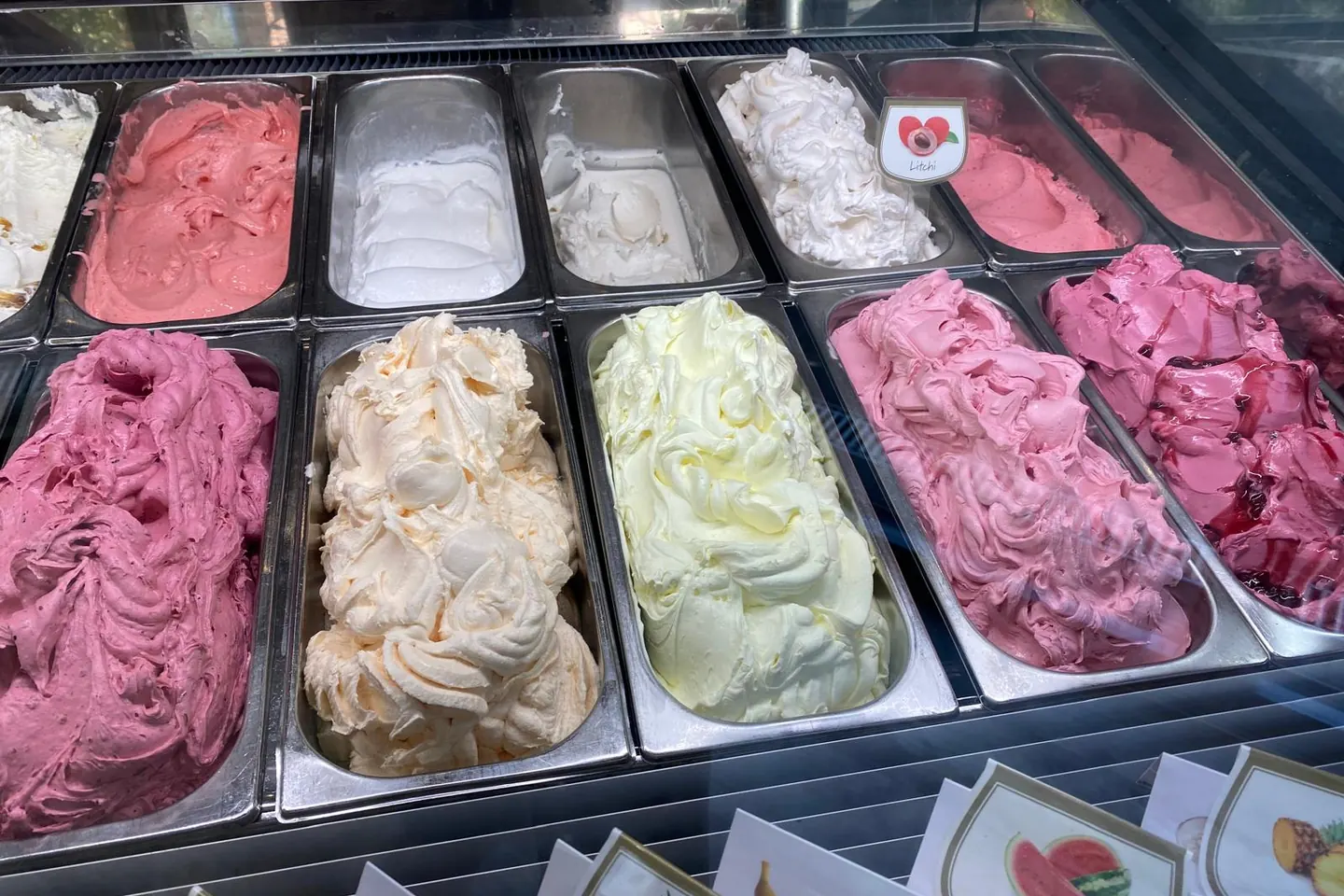 Eisvitrine mit frisch aufgezogenen Sorten in Rosa, Weiß und Pistaziengrün