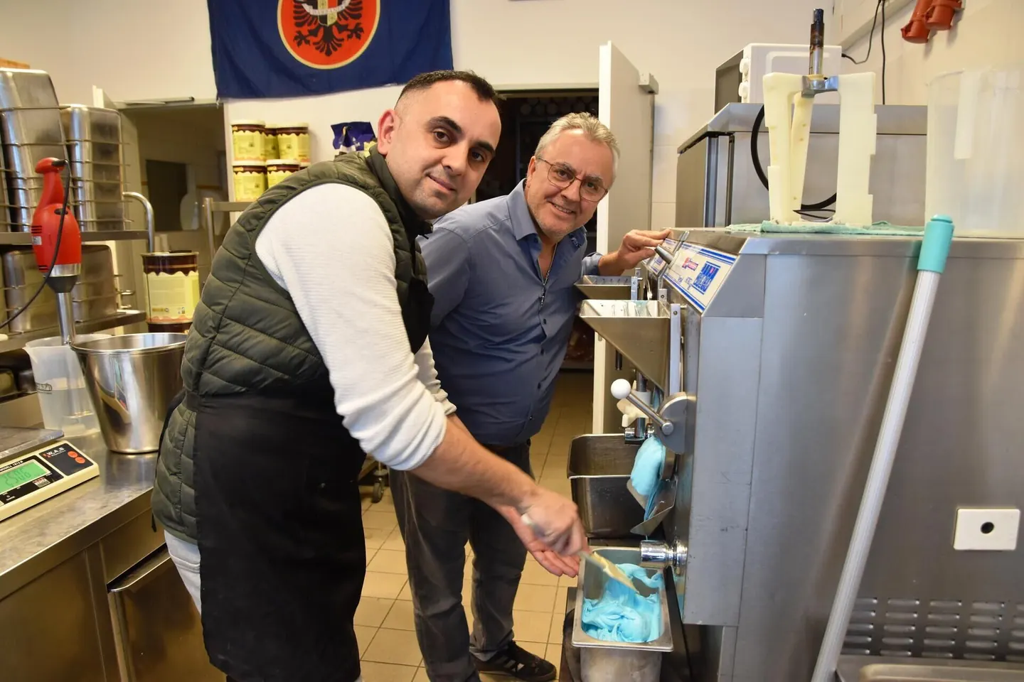 Zwei Mitarbeiter entnehmen frisch gefrorenes Eis aus der Eismaschine